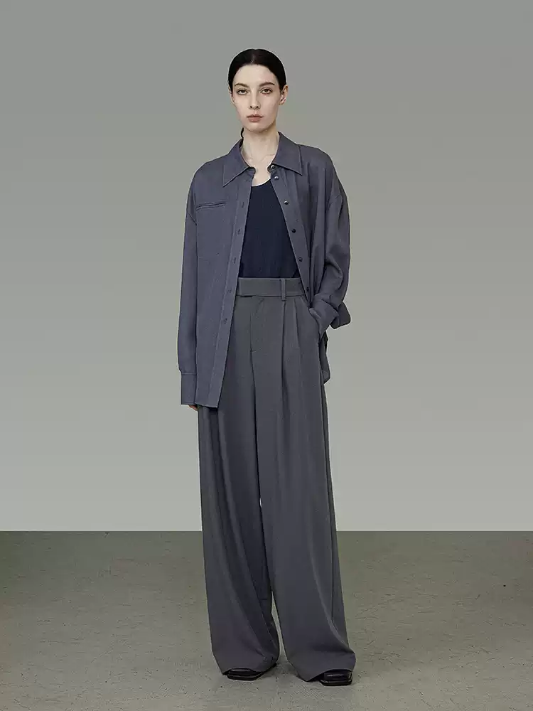 A woman in a loose suit and wide-leg pants