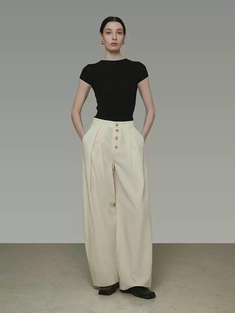 A woman wearing wide-leg pants with buttons