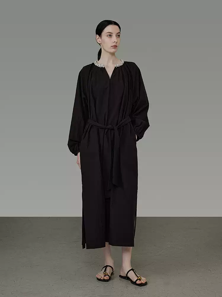 A long-sleeved V-neck dress with a pleated design