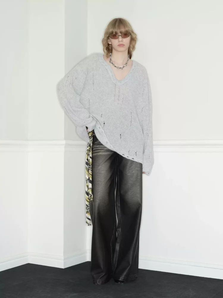 A woman in a laid-back grey heart-neck sweater