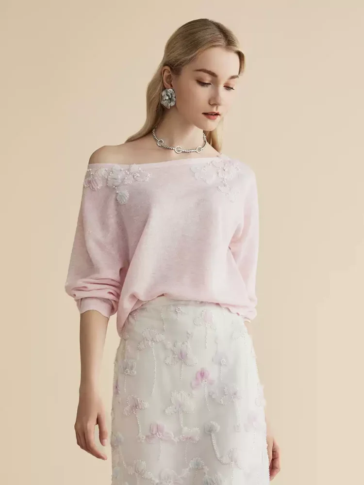 A light pink off-the-shoulder beaded knitted sweater