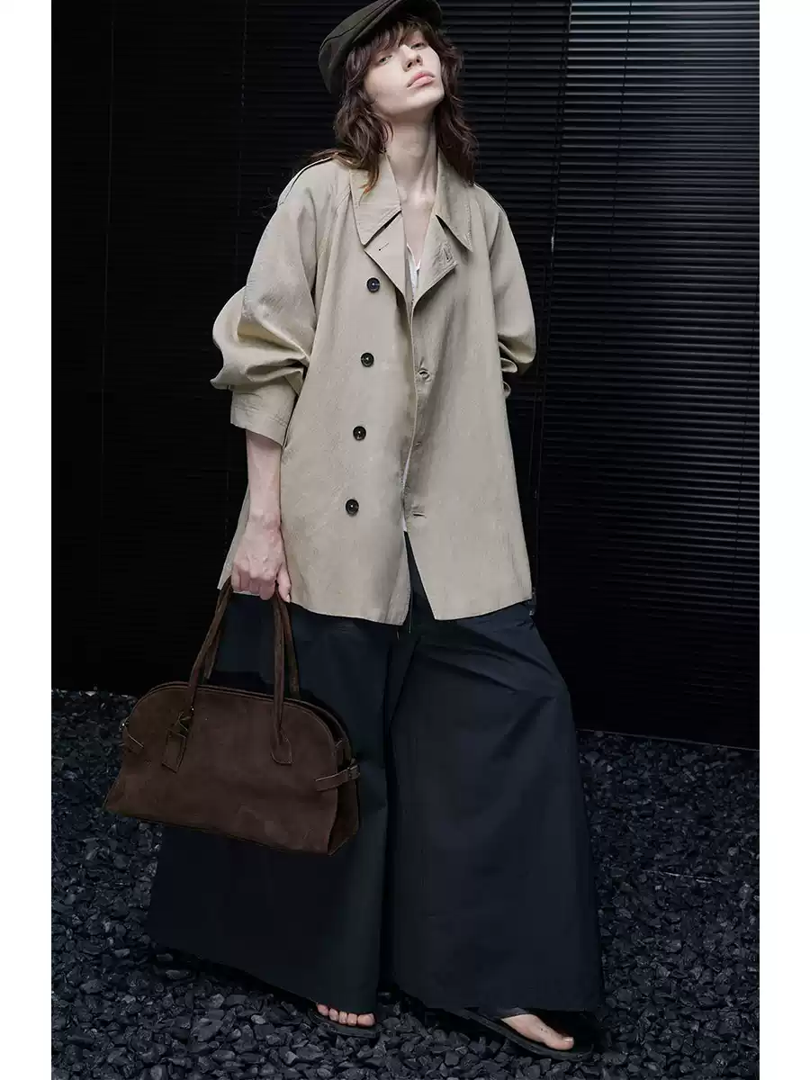 A woman wearing a light khaki windbreaker